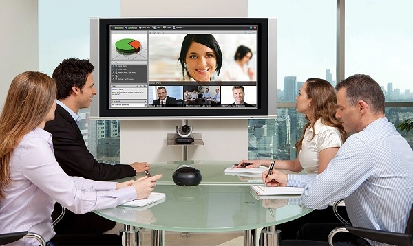 Group of business people having a video conference meeting. Sitting around a conference table talking and networking.