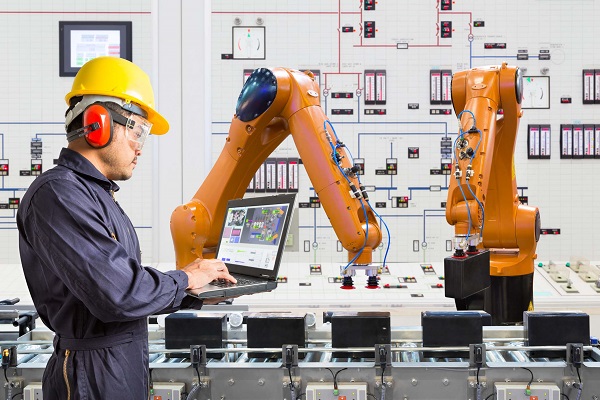 A Senior Industrial Person Operating Collaborative Robot Through His Laptop.