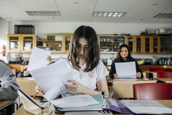 In a business management school, students are studying by referring the notes they have in hands.