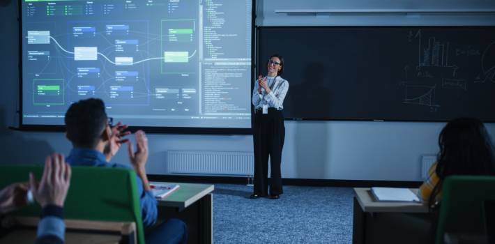 Image of a trainer and trainees sitting in a data science training room applauding after a session.